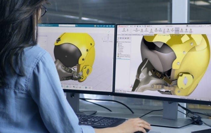 Frau im blauen Hemd vor Bildschirmen mit 3D Sculptor Anwendung